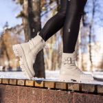 Femme en bottes blanches tendance sur neige blanche, gros plan. Jambes pour Femme dans des bottes en cuir d'hiver élégantes Photo Stock Alamy